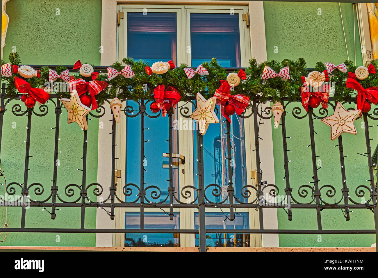 Christmas decorations on the railing of a balcony of a pastel ...