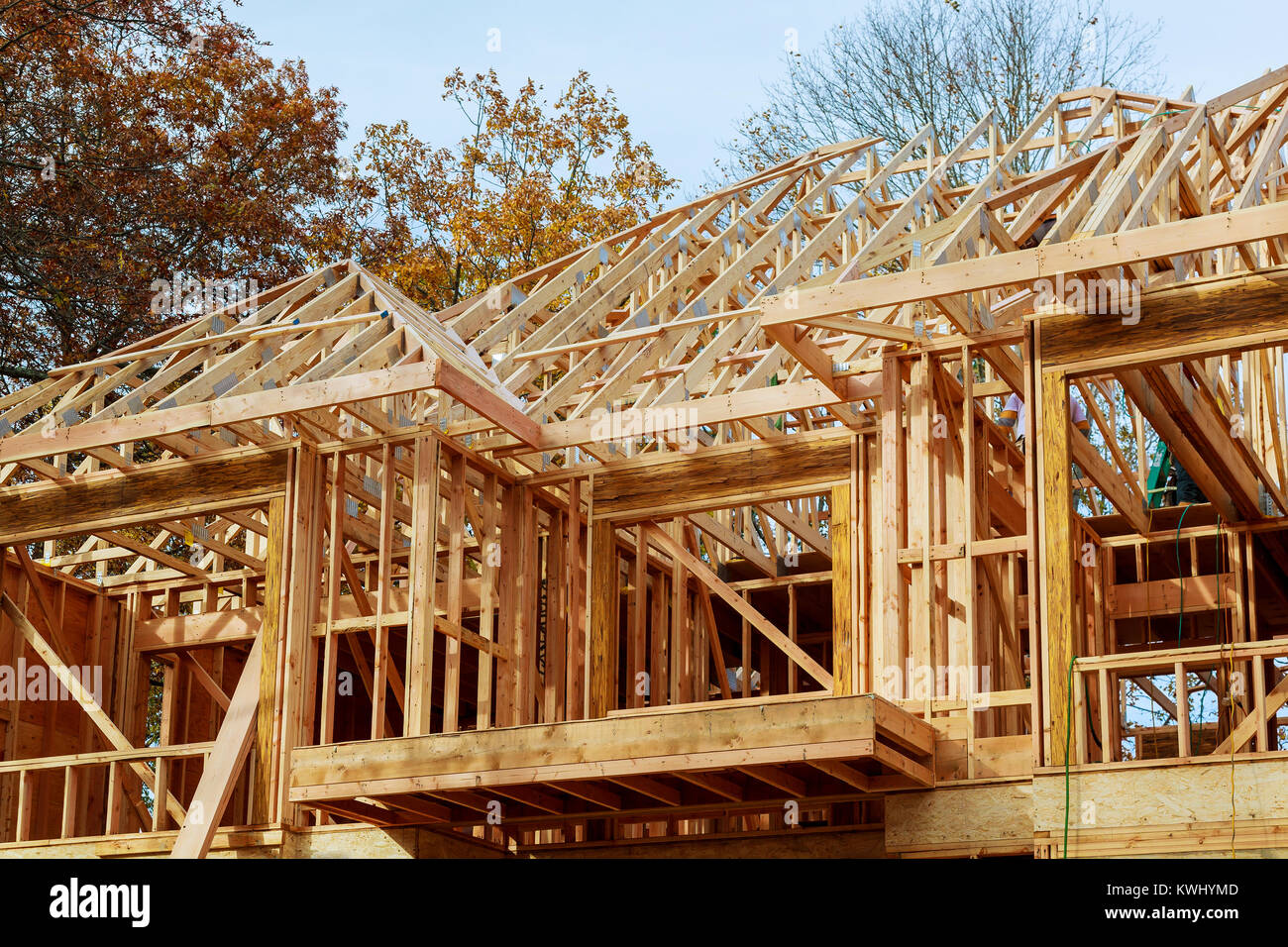 A stick built house under construction New build roof with wooden truss, post and beam framework. Stock Photo