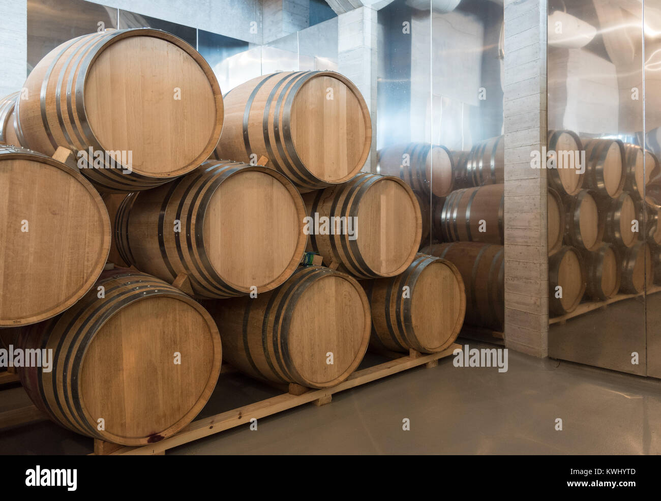 Wine wooden barrels stacked in the basement of the cellar of a winery Stock Photo