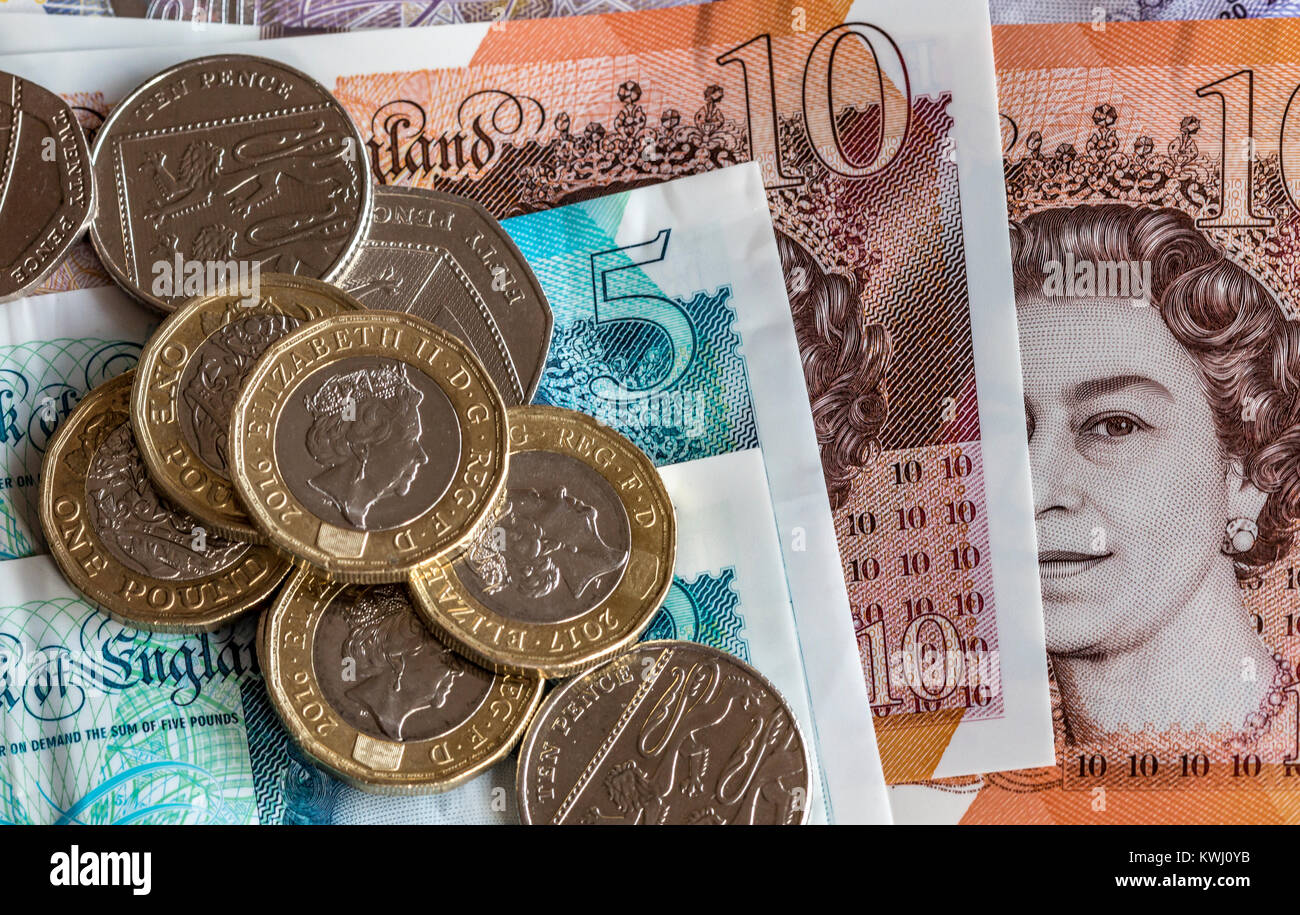 Close up of British currency , £10 pound notes £20 note and £1 coins and other assorted change. Stock Photo