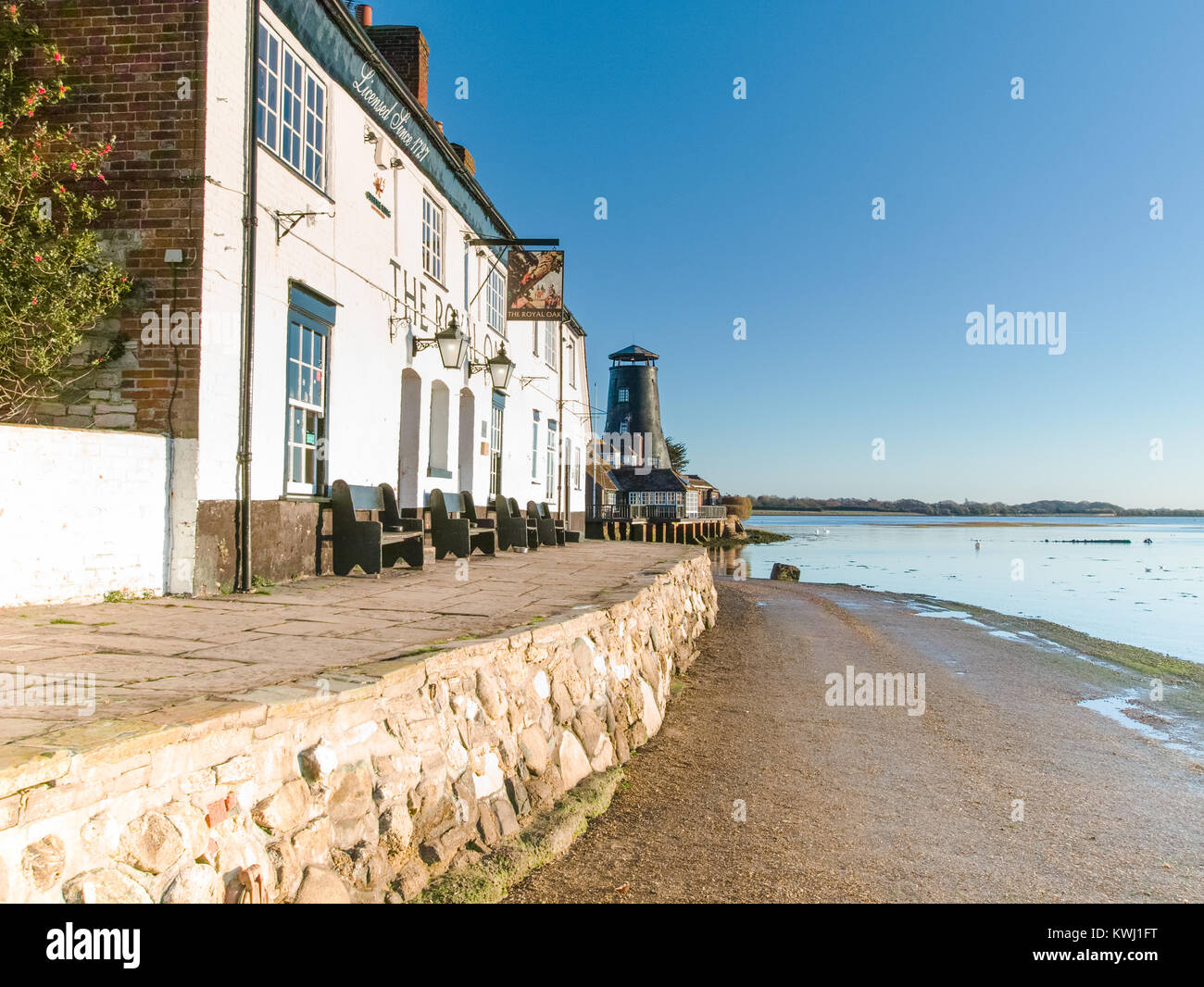 Langstone Harbour with Mill and Royal Oak on mid-winter morning at sunrise with bright winter sun and high tide Stock Photo