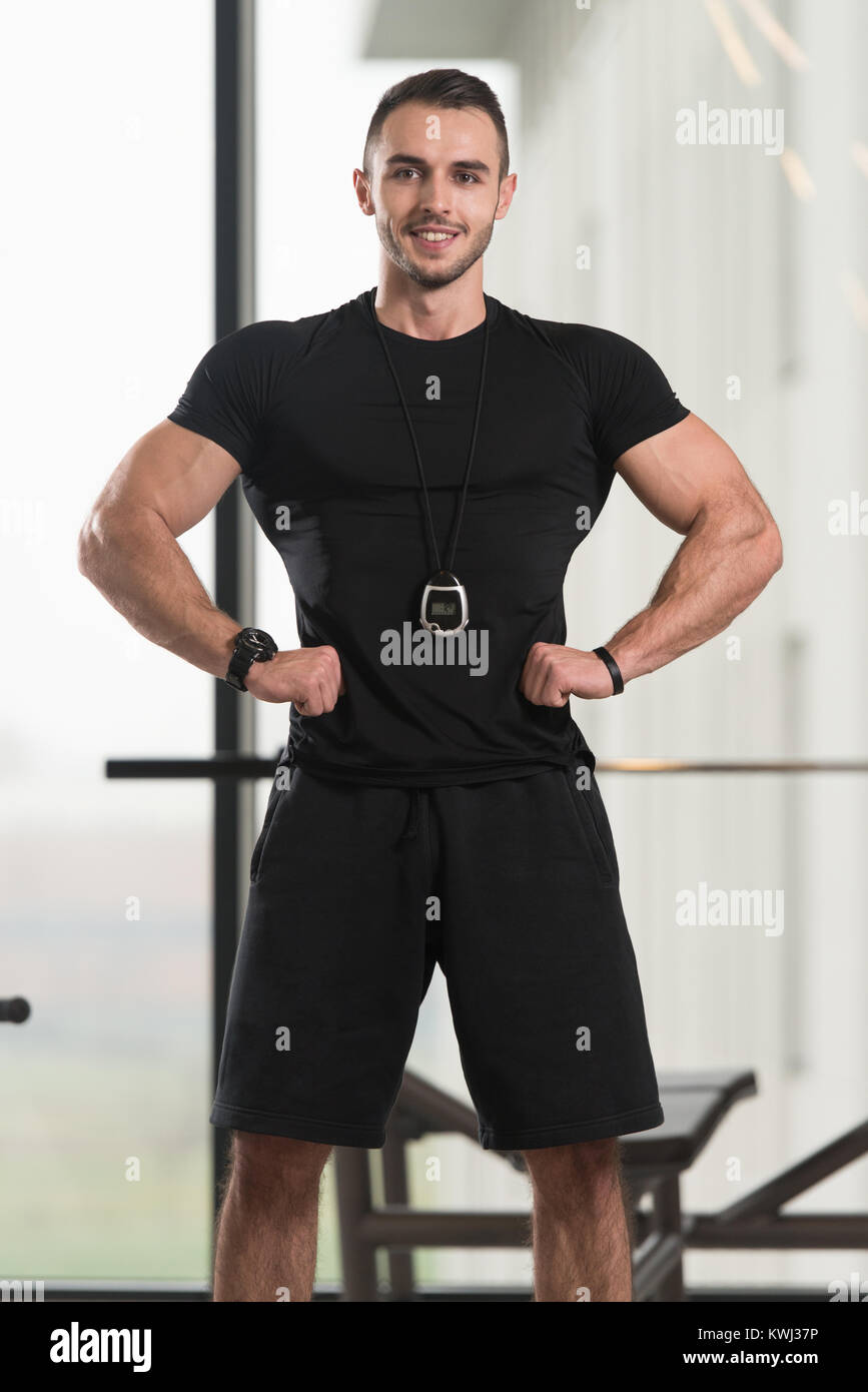 Handsome Personal Trainer With Stopwatch In A Fitness Center Gym