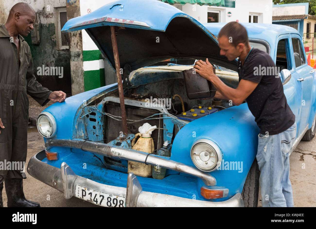 Cuban man repairs his blue Buick vintage car at the gas station in Santa Clara Cuba - Serie Cuba Reportage Stock Photo