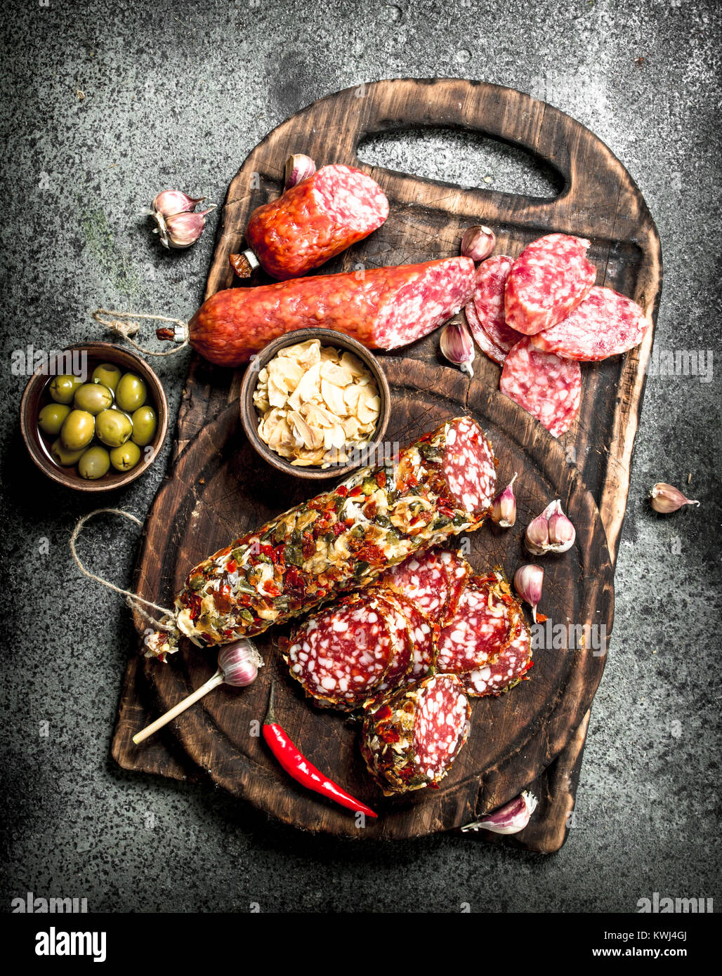 variety of salami with spices and herbs. On a rustic background Stock ...