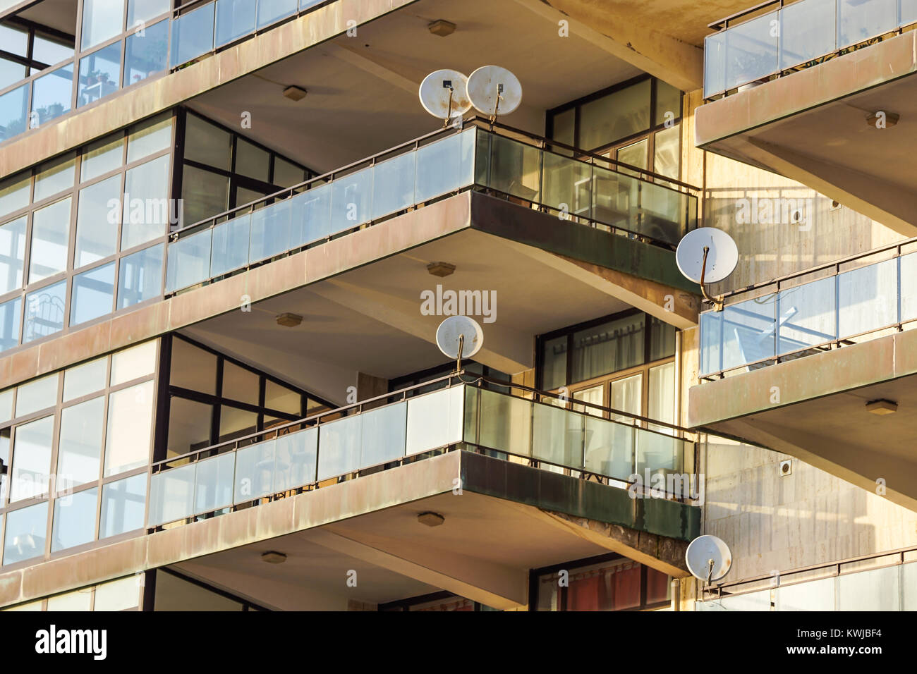 Facade of the reseidential building with windows and balconies and satelite antennas Stock Photo