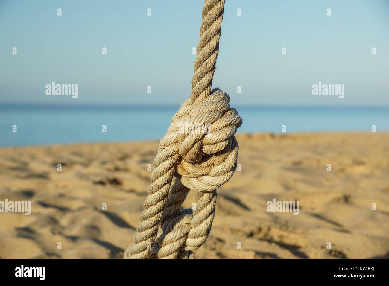 Detail of rope railing of beach walkway, old metal pole, seaside ...