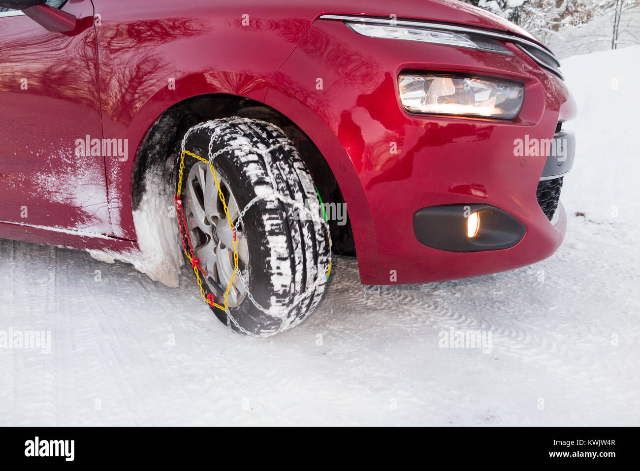 Snow chain / chains on front wheel / wheels / tyres / tires of a car in