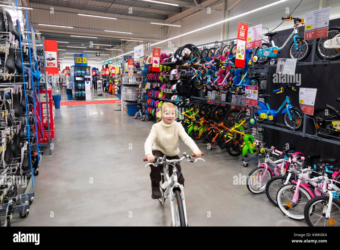 Children ride new bikes on sale in Decathlon store / shop / sports equipment retailer in France / French superstore at Grésy-sur-Aix