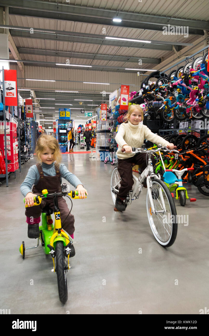 Children ride new bikes on sale in Decathlon store / shop / sports equipment retailer in France / French superstore at Grésy-sur-Aix