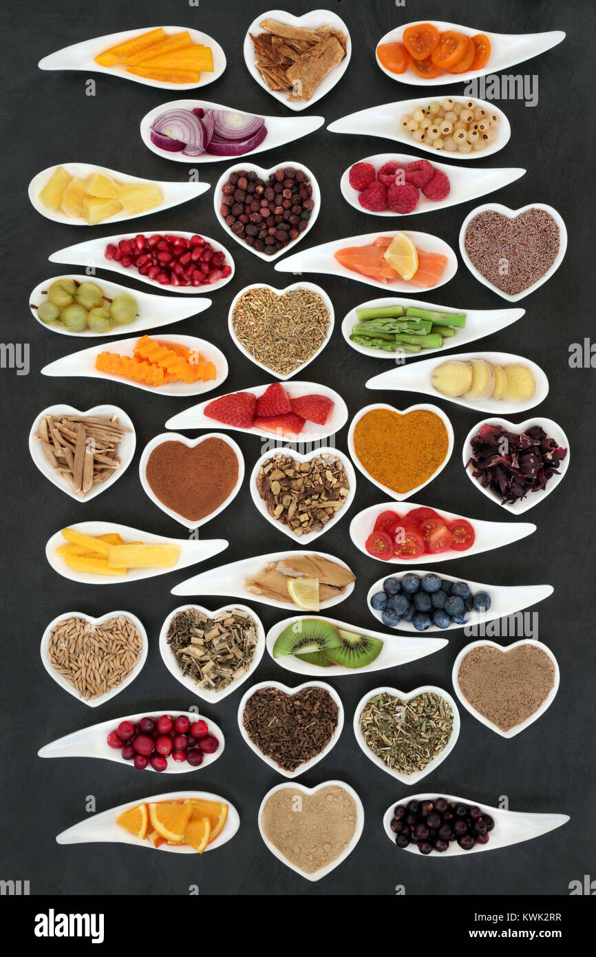 Superfood nutrition for a healthy heart concept with fresh vegetables, fruit, fish, supplement powders and medicinal herbs. Foods very high in antioxi Stock Photo