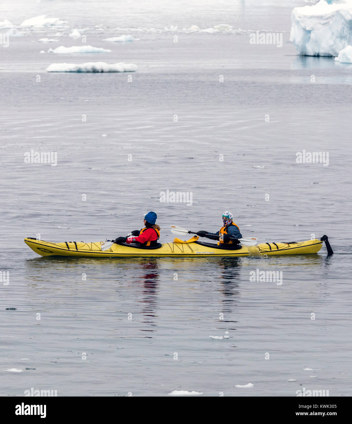 Kayakers explore snow covered Cuverville Island; Antarctica Stock Photo