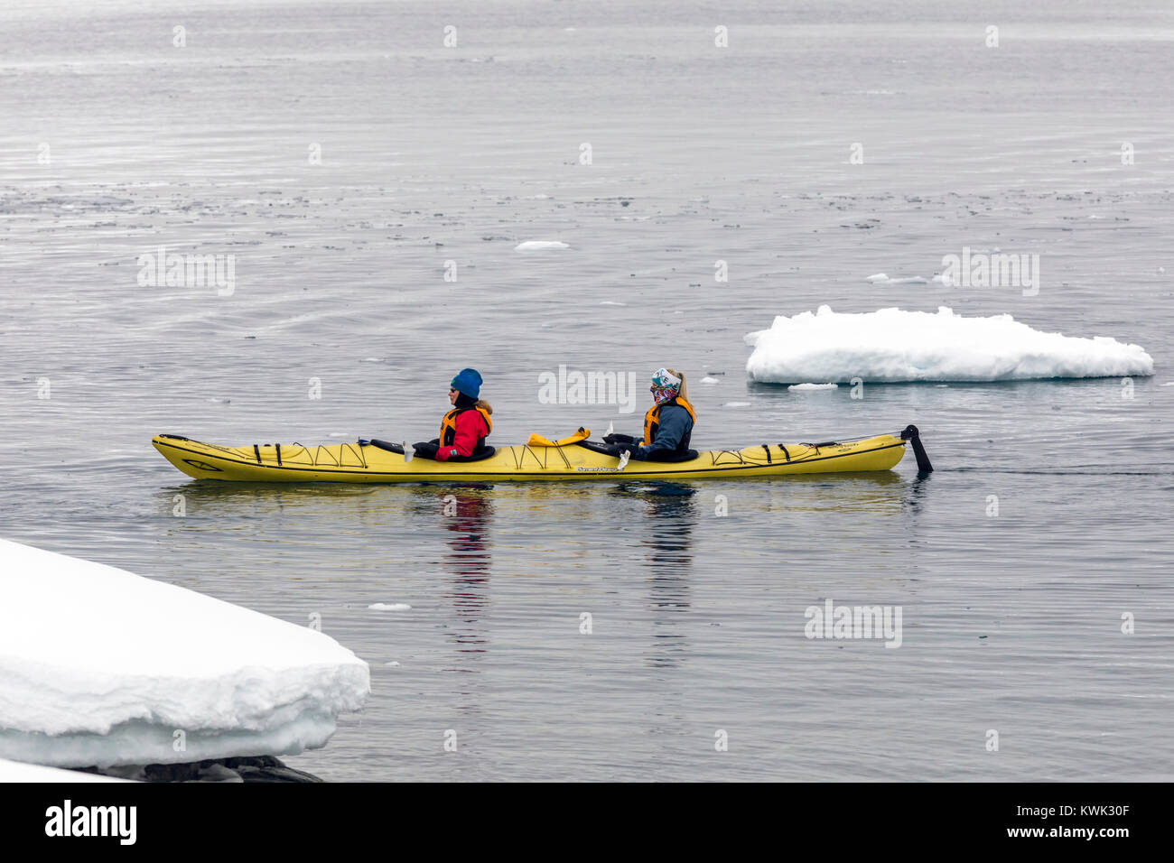 Kayakers explore snow covered Cuverville Island; Antarctica Stock Photo