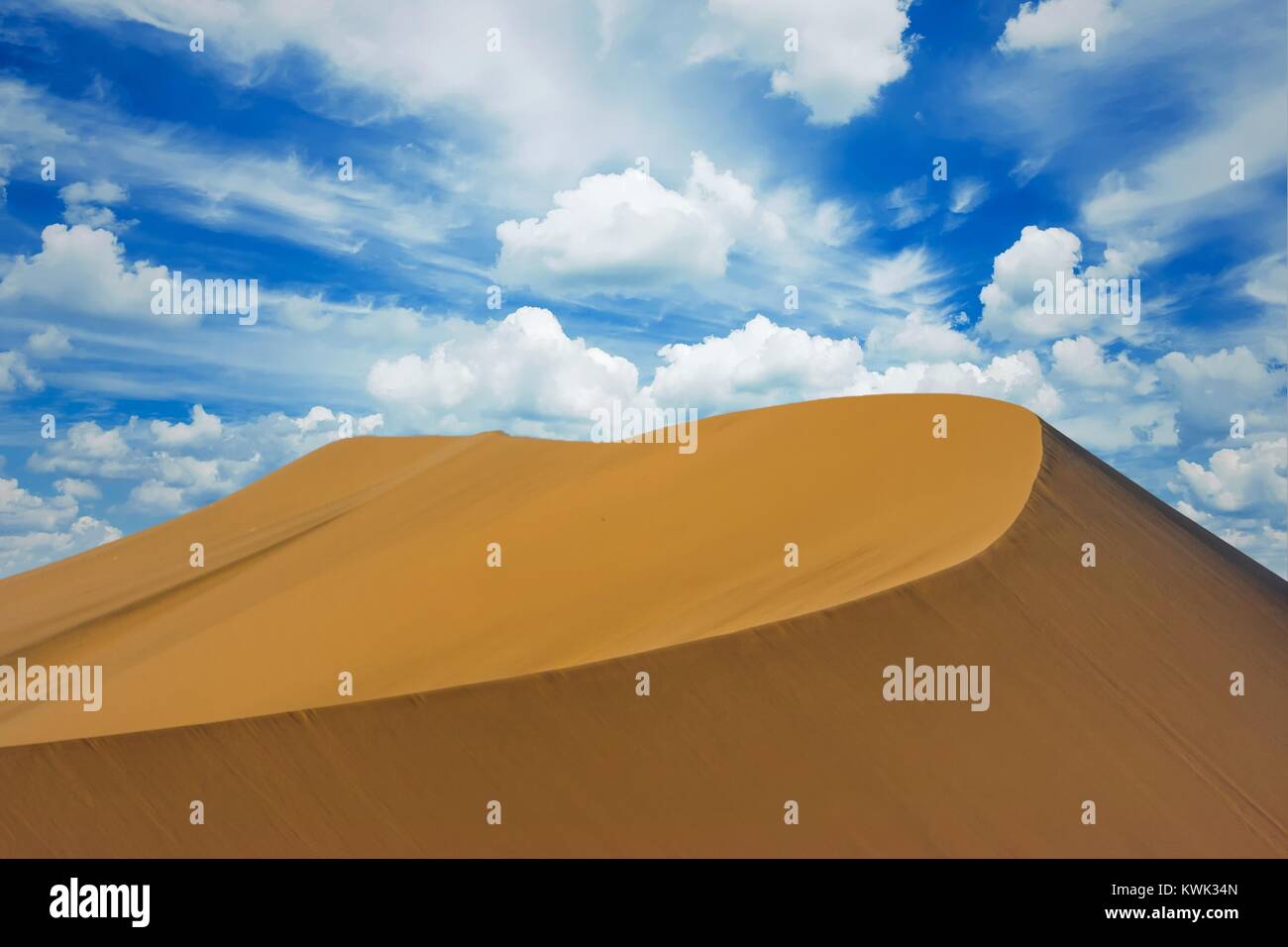 Panoramic picture of a sand dune with a big blue sky with clouds ...