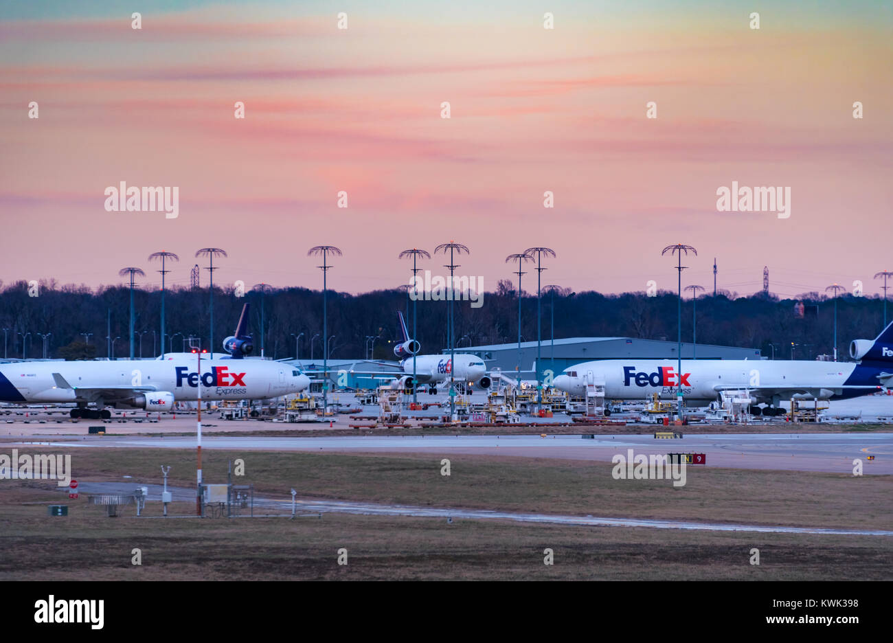 FedEx Express jets at Memphis International Airport, FedEx's world hub, under a colorful sunset sky. (USA) Stock Photo