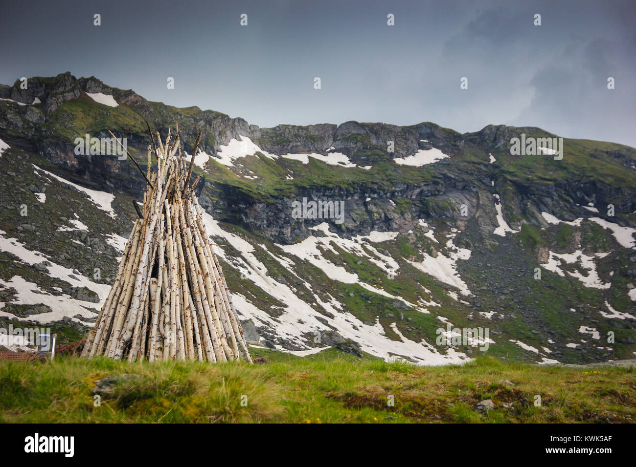 Big pile of logs ready for a camp fire at Balea Lac with Fagaras Mountains in the background in Sibiu County, Romania Stock Photo