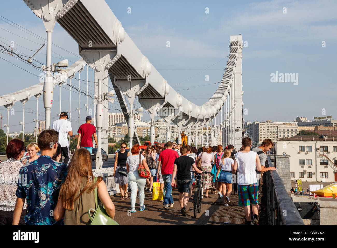 Krymsky Bridge with unidentified people heading for the Gorky Park on a sunny day. Moscow, Russia. Stock Photo