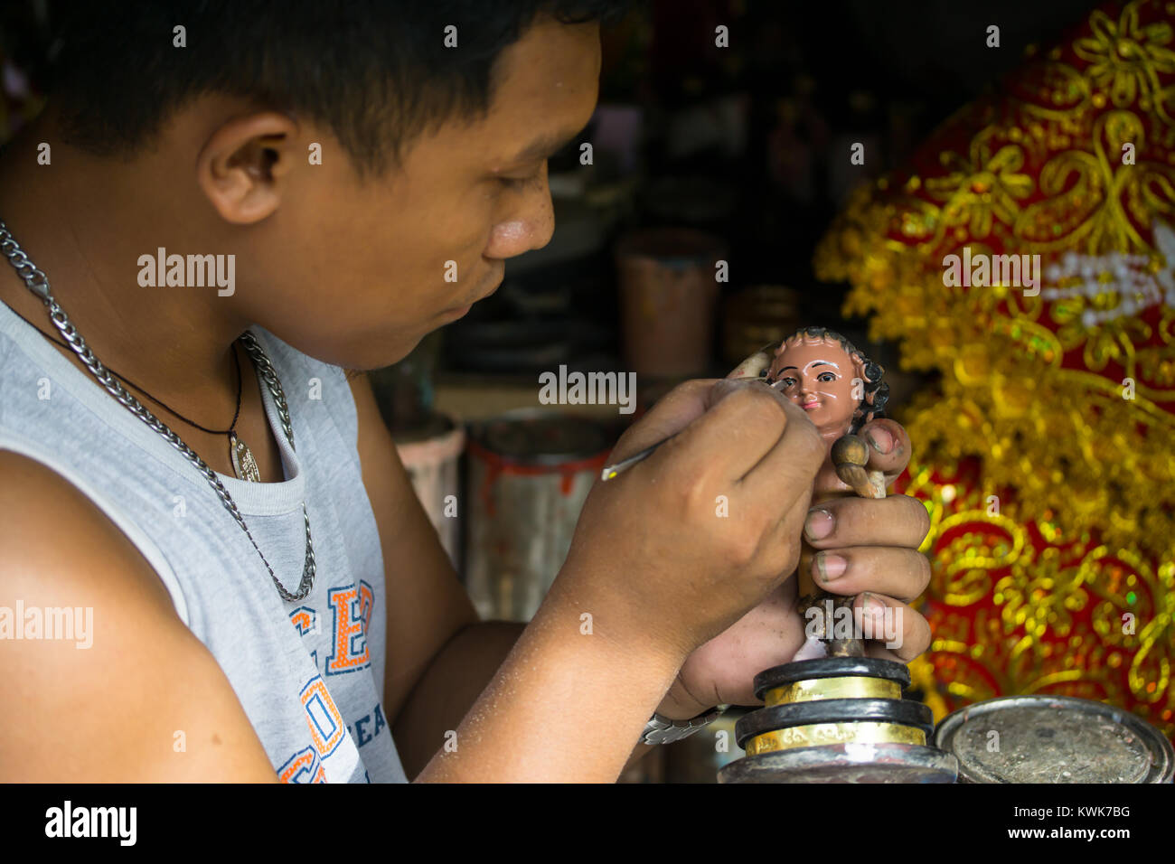 Street Vendor repairing & painting religous statue of a Santo Nino,child Jesus figurine,Cebu City,Philippines Stock Photo