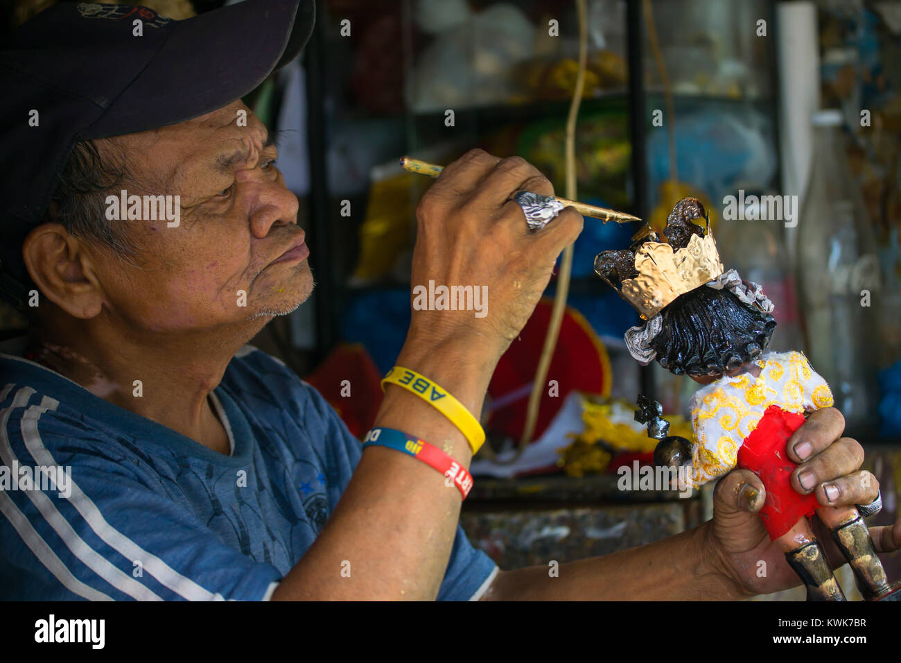 Street Vendor repairing & painting religous statue of a Santo Nino,child Jesus figurine,Cebu City,Philippines Stock Photo