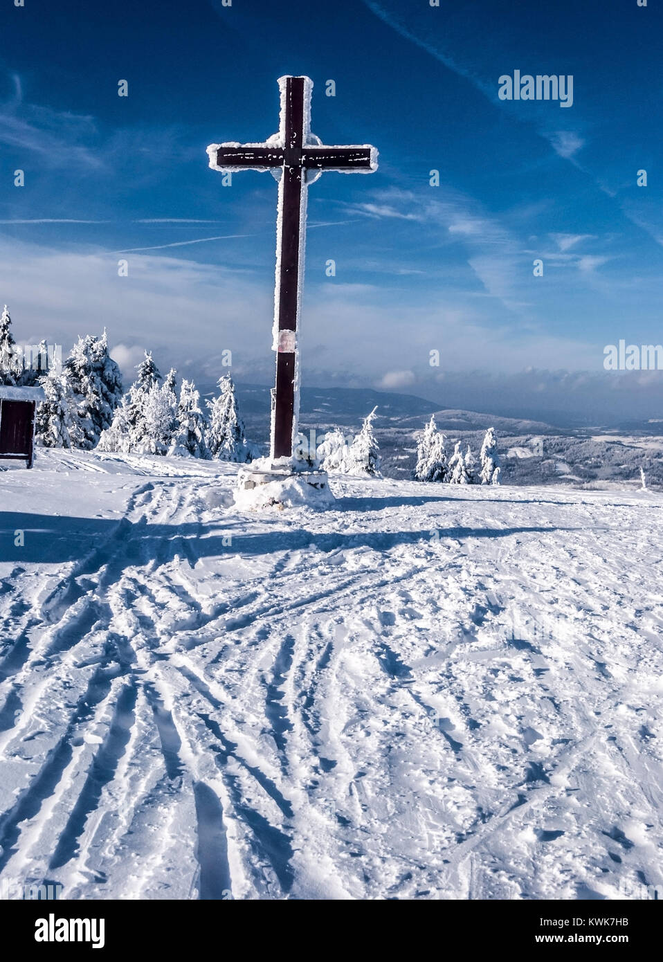 cross on Velka Raca hill in Kysucke Beskydy mountains on slovakian - polish borders during winter day with snow and blue sky Stock Photo