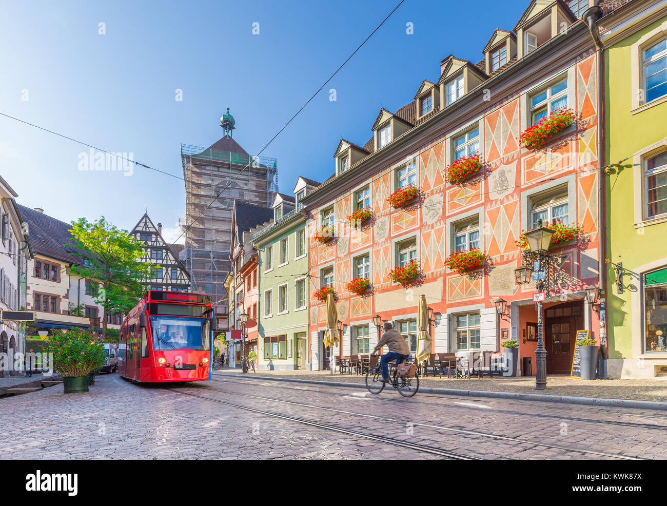 Historic town of Freiburg im Breisgau with tram and famous medieval Schwabentor (Swabian Gate) town gate in beautiful golden morning light at sunrise  Stock Photo