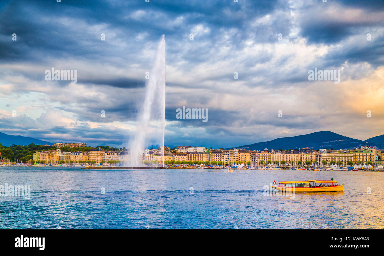 Panoramic view of historic Geneva skyline with famous Jet d'Eau fountain at harbor district in beautiful evening light at sunset, Switzerland Stock Photo