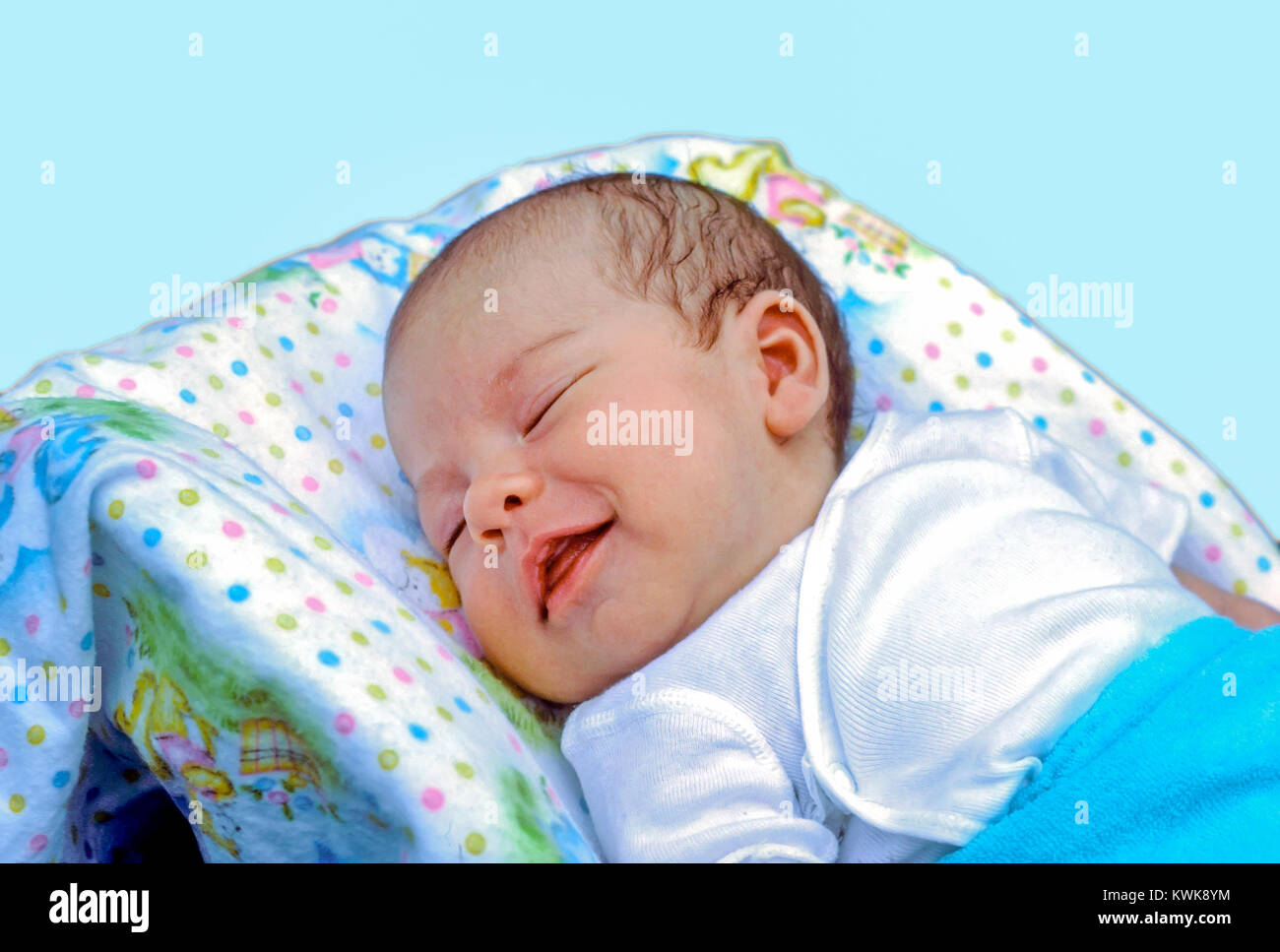 A newborn baby boy laying in his bed sleeping has a big smile on his face at home in Hudson, Massachusetts, United States. Stock Photo