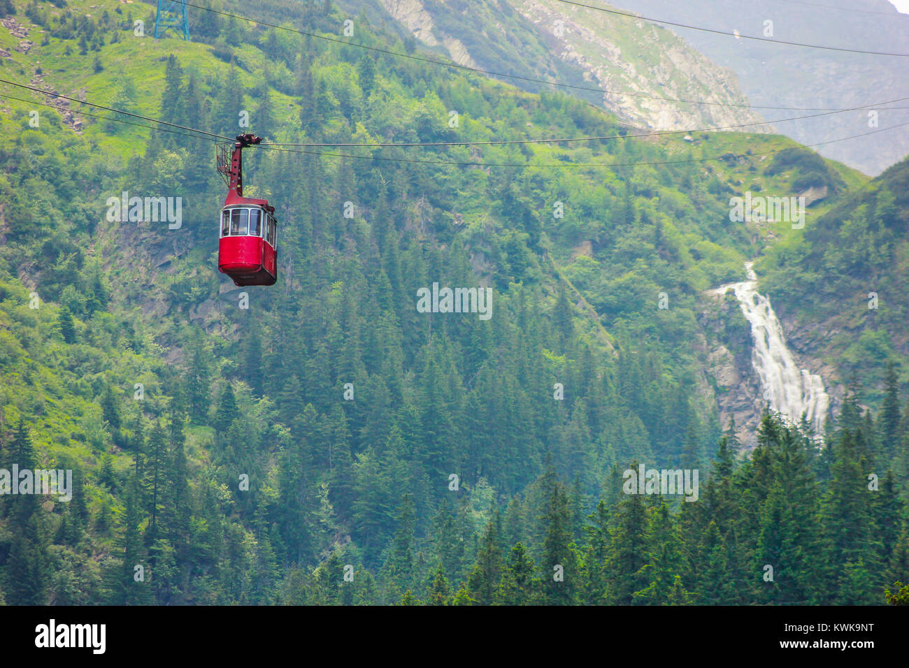 Cable car with green woods and Balea Cascada waterfall background in Sibiu, Romania Stock Photo