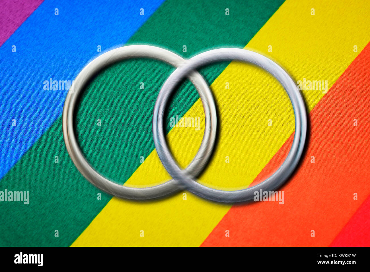 Two wedding rings before rainbow flag, symbolic photo same-sexual marriage, Zwei Eheringe vor Regenbogenfahne, Symbolfoto gleichgeschlechtliche Ehe Stock Photo