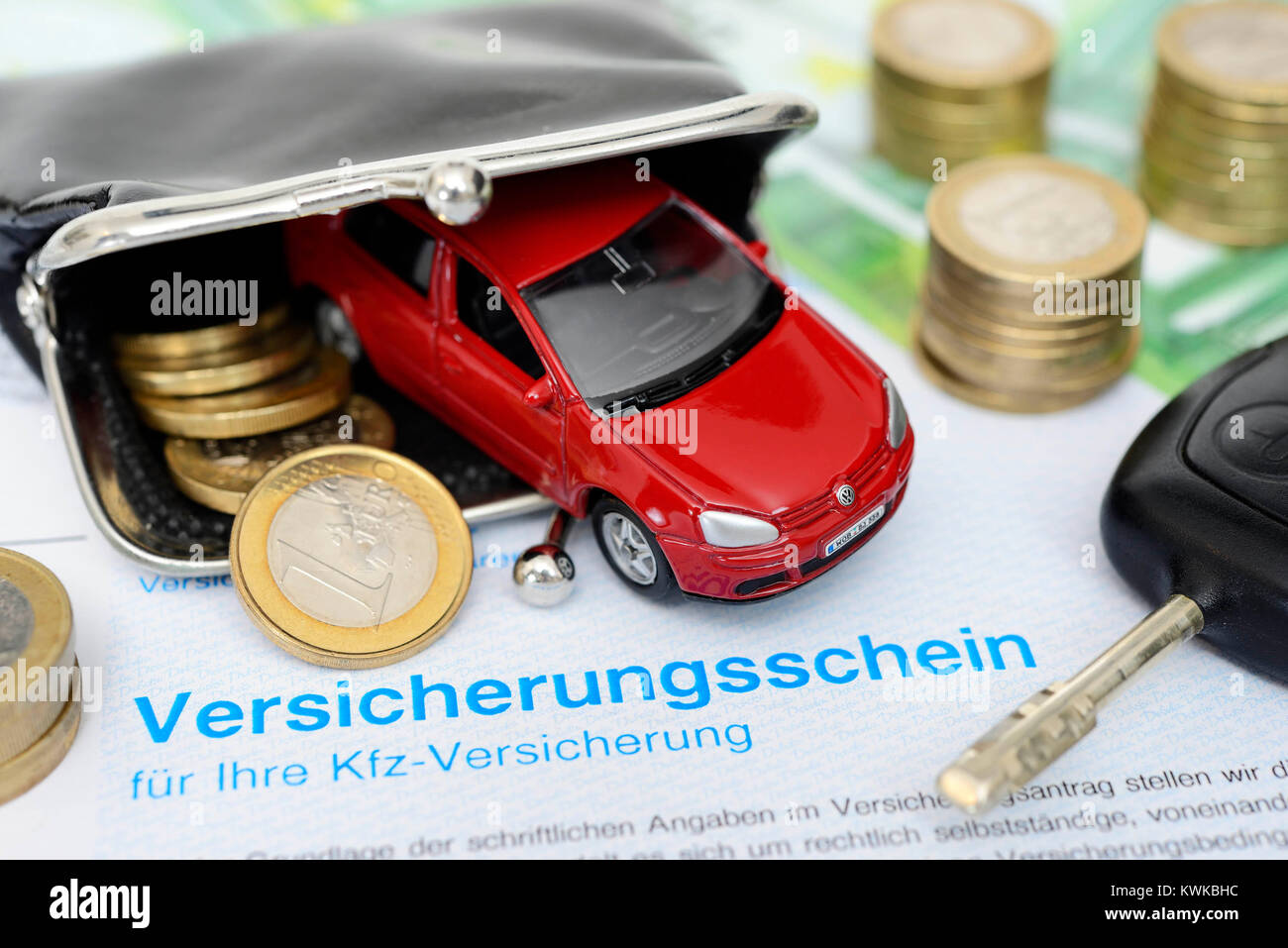 Miniature car in the purse and insurance policy, vehicle assurance, Miniaturauto im Portemonnaie und Versicherungsschein, Kfz-Versicherung Stock Photo