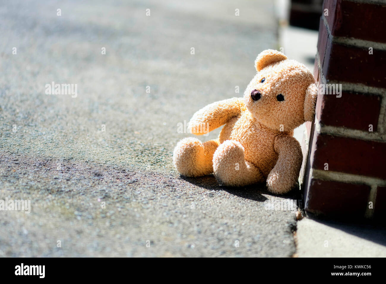 Material Teddy sits on the ground, symbolic photo childhood trauma and power, Ein Stoff-Teddy sitzt auf dem Boden, Symbolfoto Kindheitstrauma und Gewa Stock Photo