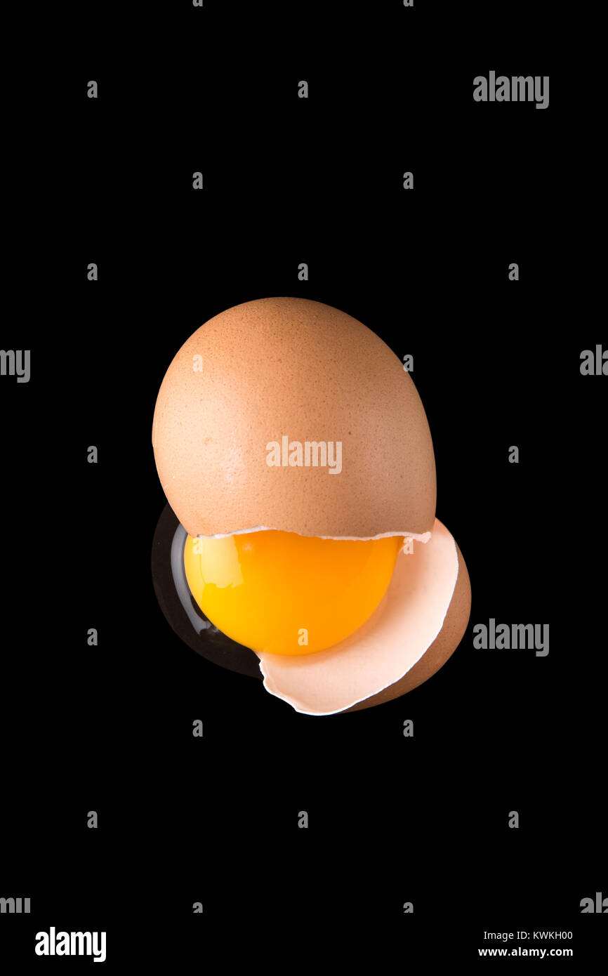 Concept image of a cracked egg on a black background Stock Photo - Alamy