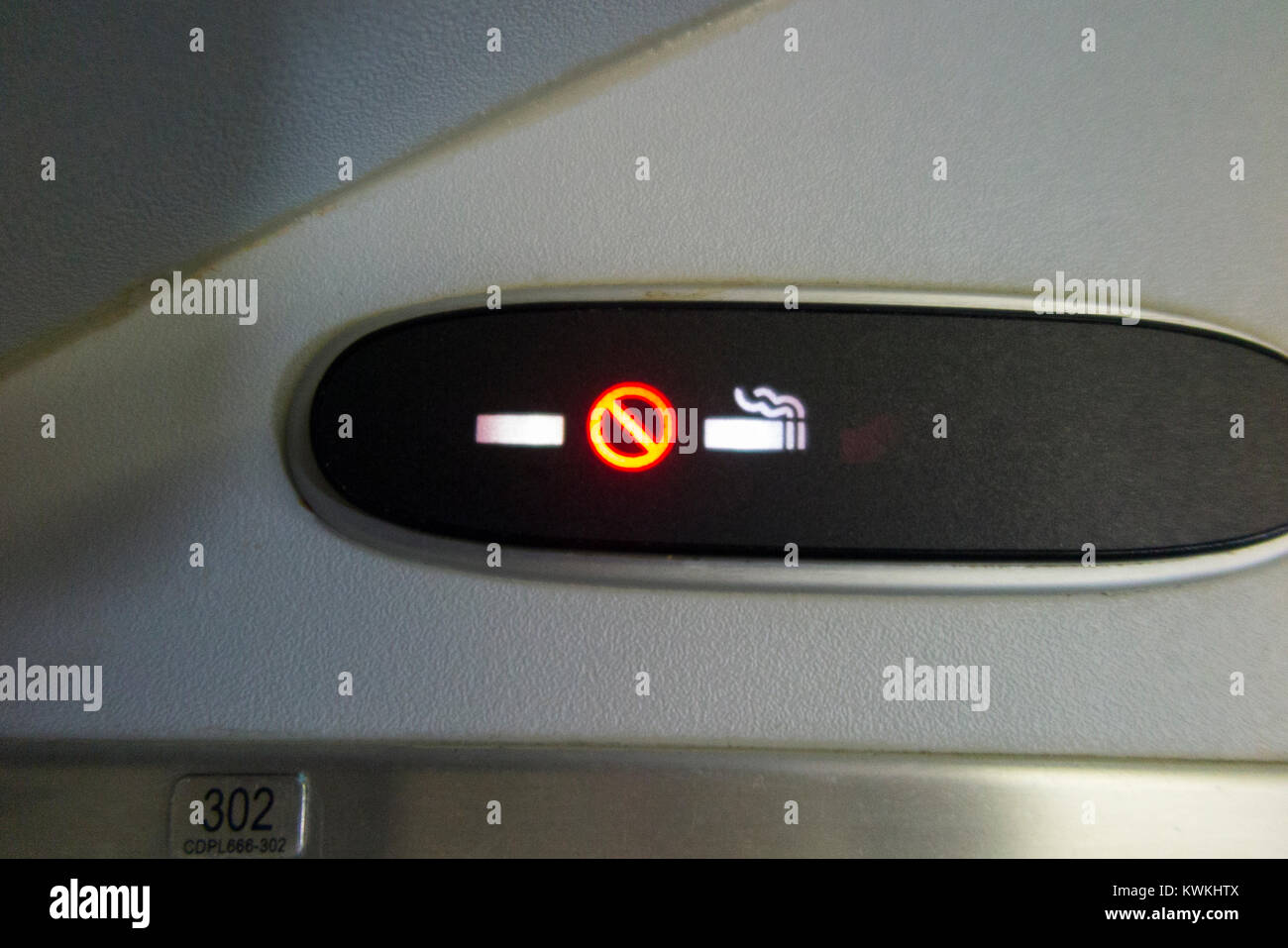 Aircraft 'no smoking' / none / non cigarette sign lit up & illuminated during a flight in an Embraer 190 plane / aeroplane / airplane. (93) Stock Photo