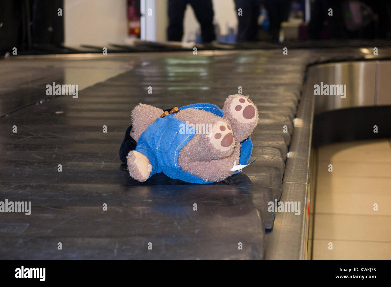 Child's soft toy, a Paddington Bear – possibly lost –  riding luggage claim / baggage reclaim carousel conveyor belt at London City Airport. UK. (93) Stock Photo