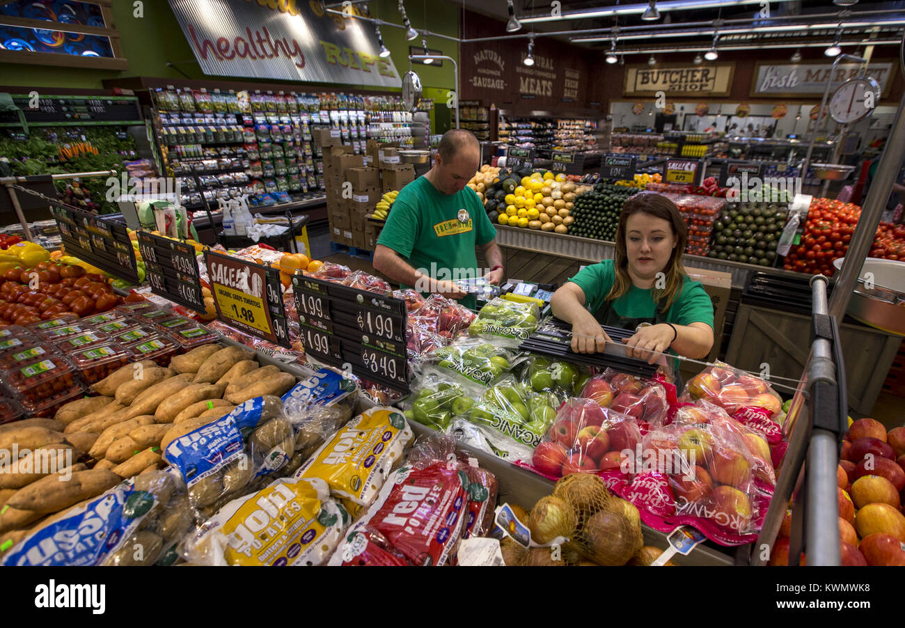 Grocery clerk working in produce aisle of supermarket store Stock Photo by  ©FreeProd 118794062