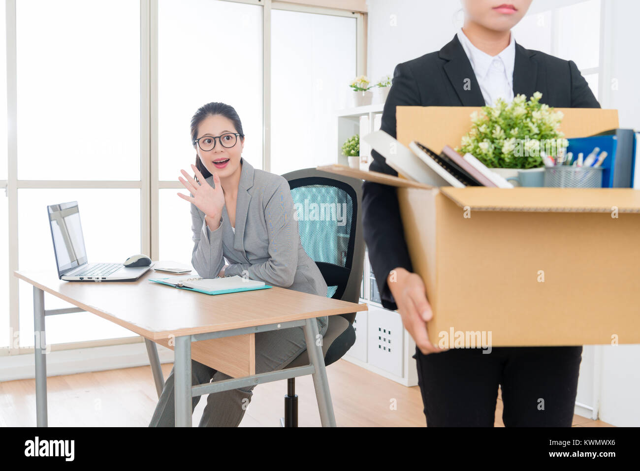 sadness young business woman losing job packing personal items box leaving company and her colleague feeling happy say goodbye. Stock Photo