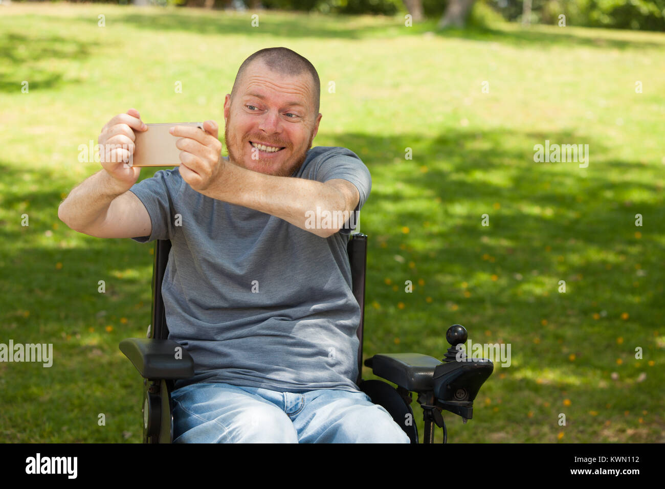 Disabled man in wheelchair doing selfie Stock Photo