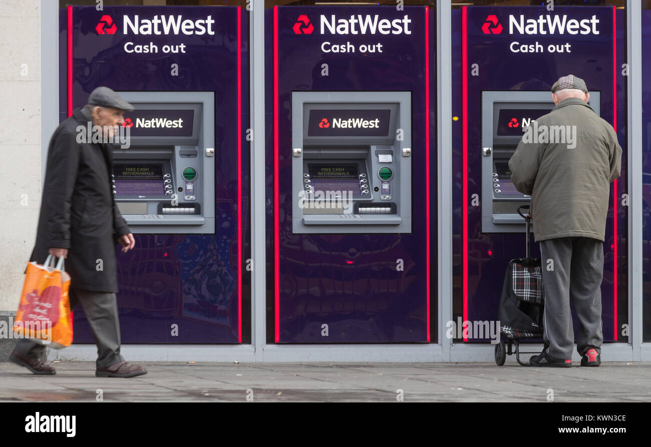 A pensioner using a cash point machine at a NatWest Bank in Southampton High Street, UK Stock Photo