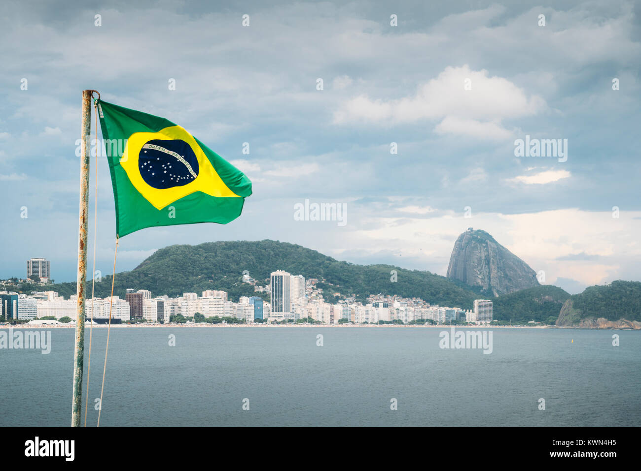 Brazilian Flag On A Pole Waving Set Against Copacabana Rio De Janeiro Brazil Background With The Iconic Sugarloaf Mountain Stock Photo Alamy