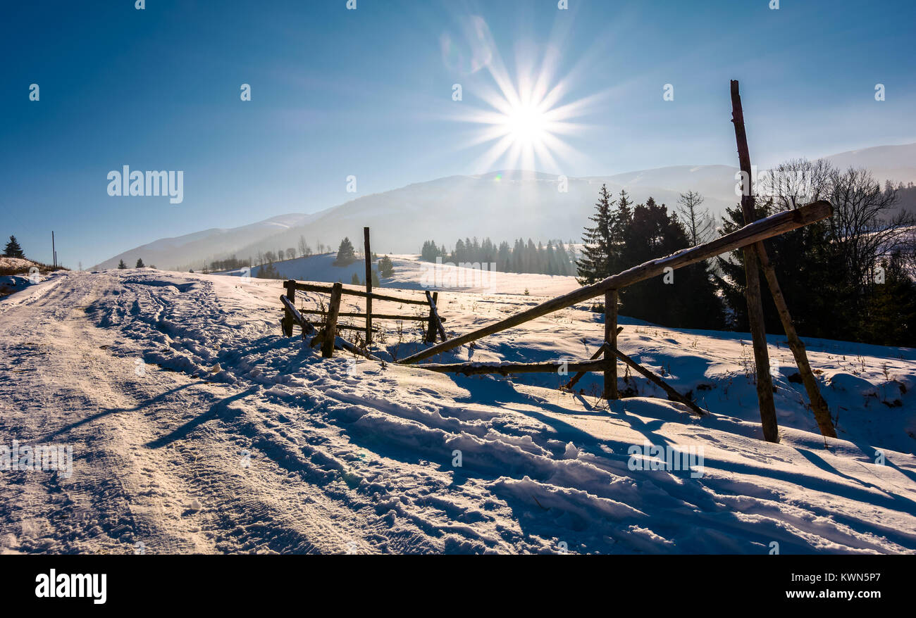 wooden fence on snowy meadow. lovely rural scenery on a bright sunny day. location Pylypets, Ukraine Stock Photo