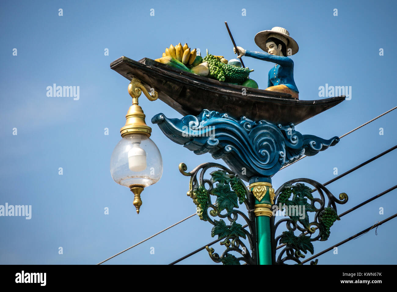 Model of Thai trader in boat on lamp post, Damnoen Saduk Floating Market, Thailand. Stock Photo