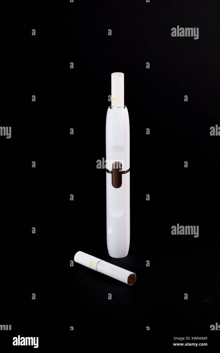 Newest electronic cigarettes, heating tobacco system IQOS, smoking, white isolated on black background Stock Photo
