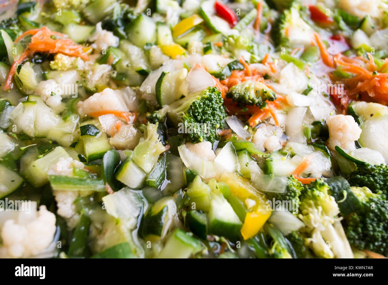 Preparation to making Piccalilli using freshly cut vegetables immersed in brine. Stock Photo