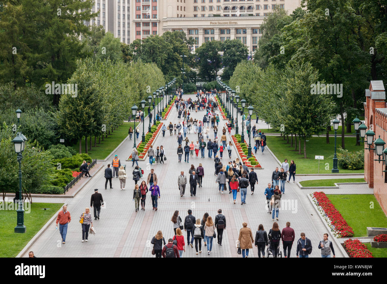 Tourists walking through the Alexandrovsky Garden, a park along the ...