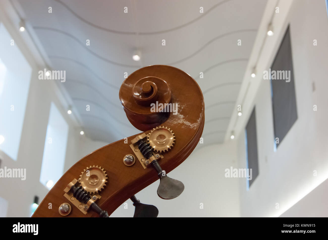 Neck head and scroll and tuning pegs of a hand carved double bass on view in the Museo del Violino, violin and string instrument museum of Cremona Stock Photo