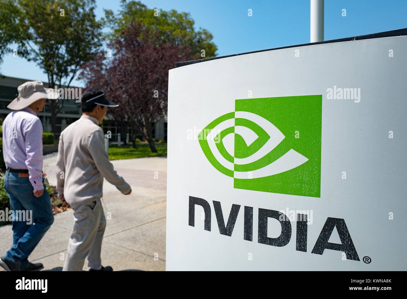 Two men walk together past signage with logo at the Silicon Valley headquarters of computer graphics hardware company Nvidia, Santa Clara, California, August 17, 2017. Stock Photo