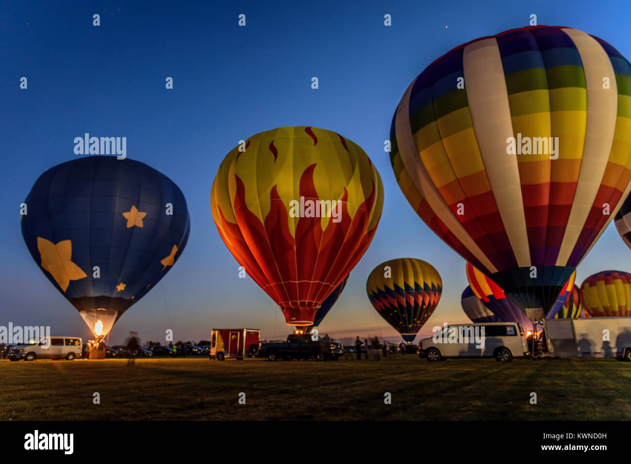 hot air balloons glowing in the night sky in Harvard, IL Stock Photo