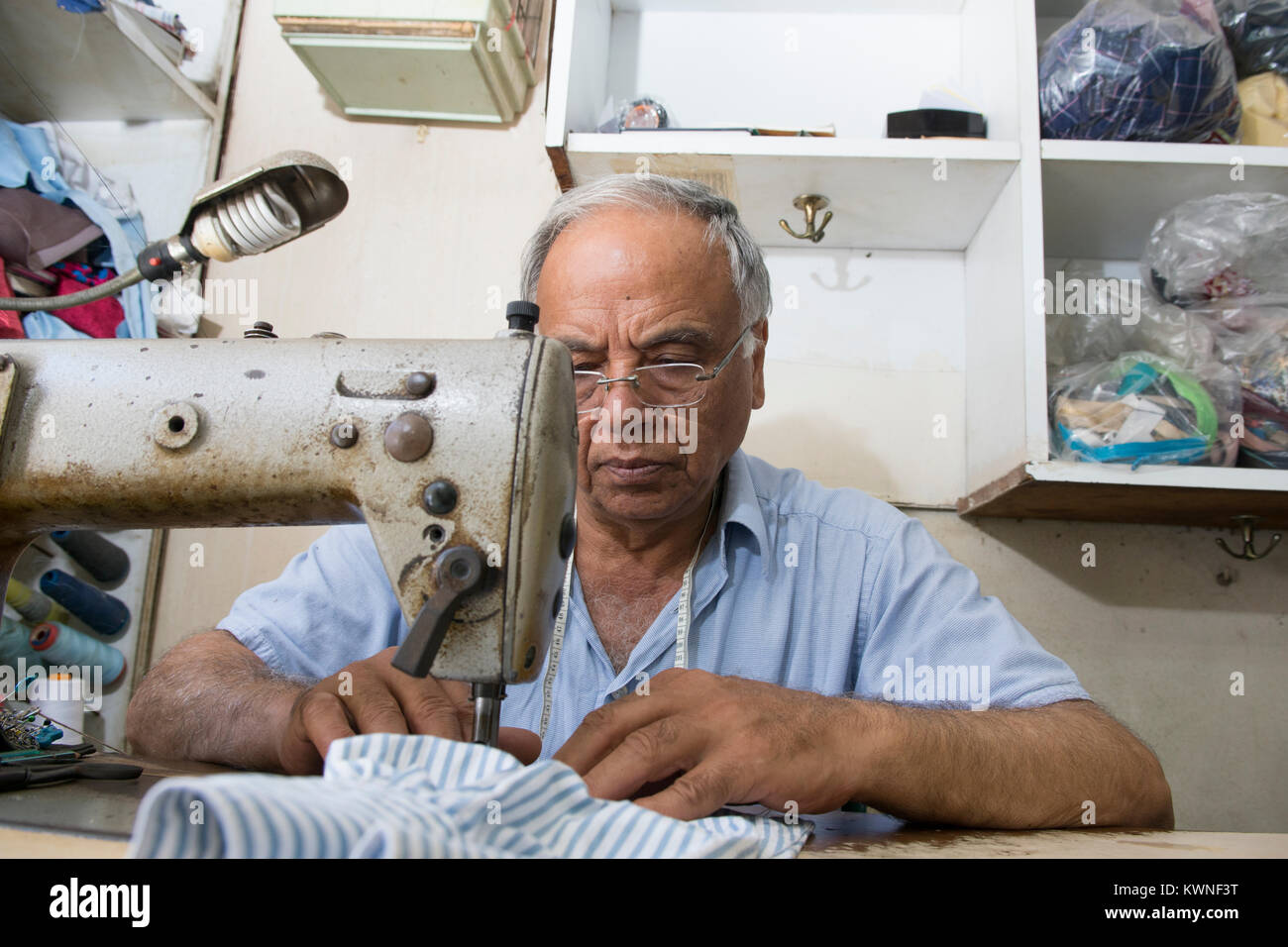 Tailor working with a sewing machine Stock Photo