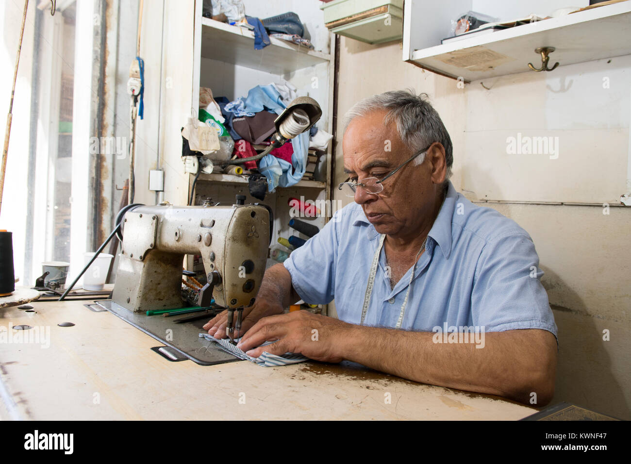 Tailor working with a sewing machine Stock Photo