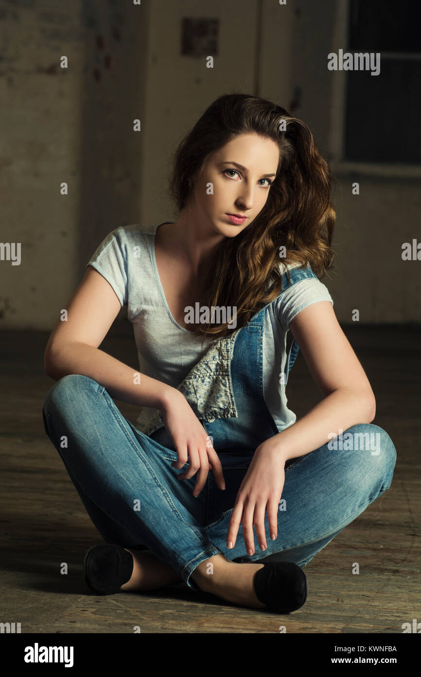 Beautiful young woman sat on the floor  Stock Photo