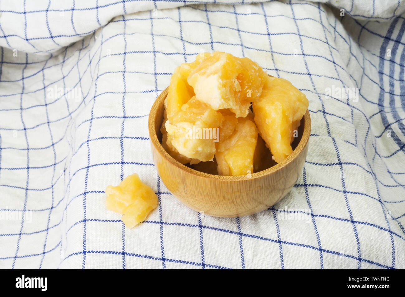 Fresh Jaggery sugar chunks from India in a wooden bowl Stock Photo